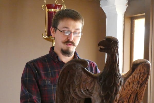 A young man reading from an eagle lectern